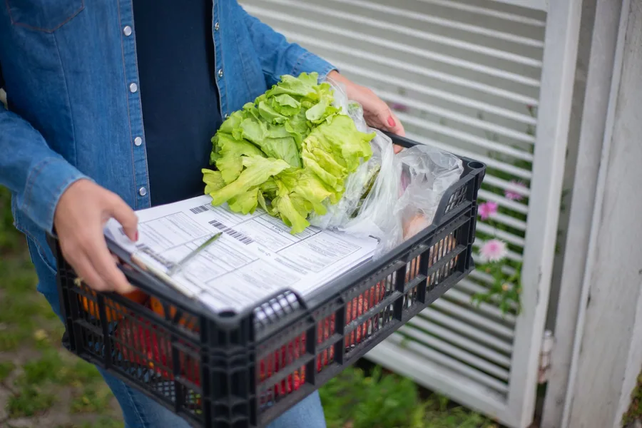 Lista de compra junto a verduras y bolsas de tela